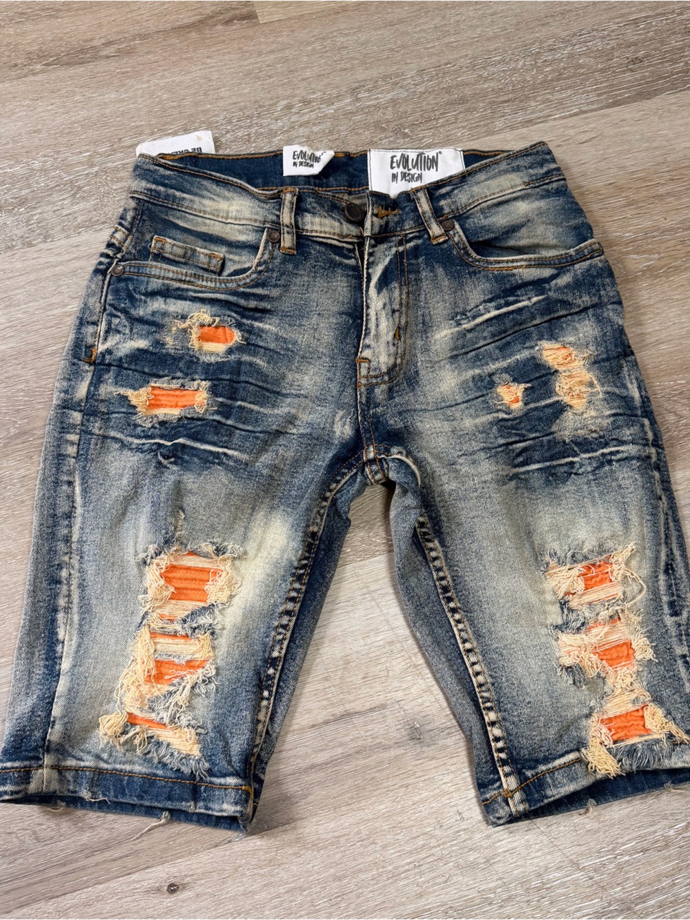 Evolution and Creation Distressed Blue Denim Shorts with Orange Patch Accents